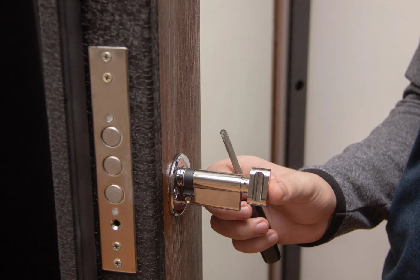 Pose d'un cylindre Bricard à clé protégée sur une porte d'entrée à Ménilmontant, Paris 20e